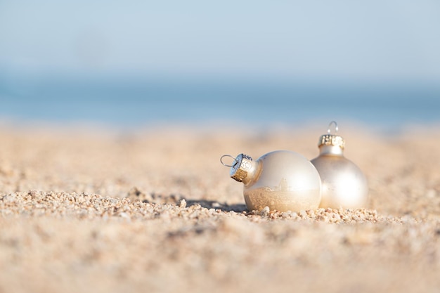海の背景の砂浜でクリスマスの装飾のボールボール