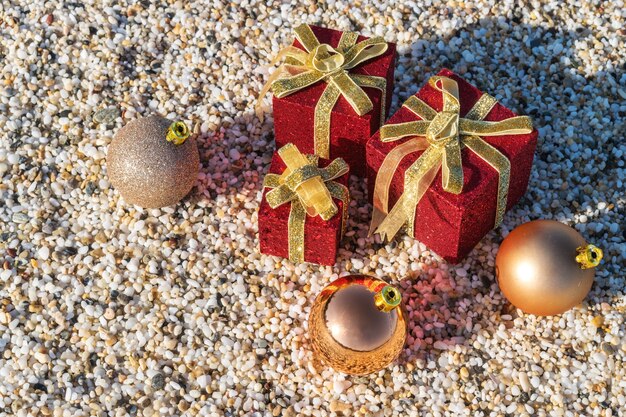 Christmas decorations and baubles in the sand on a beach