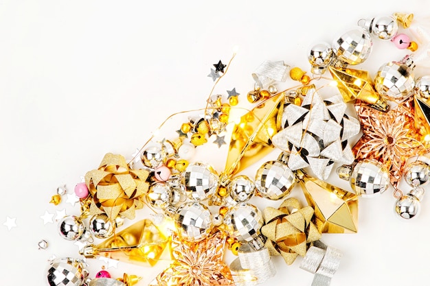 Christmas decorations, bows, stars,  bells in gold colors on white background . Holiday and celebration. Flat lay, top view