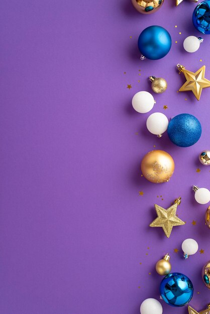 Christmas decorations concept top view vertical photo of blue white and gold baubles balls star ornaments and confetti on isolated lilac background with copyspace