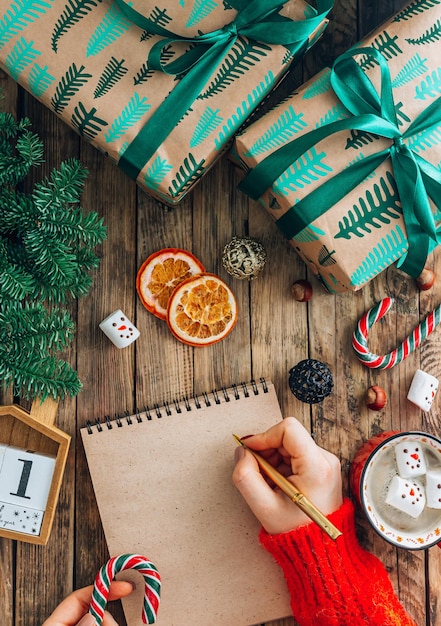 Christmas decorations on festive wooden background with copy space on notebook. Flat lay