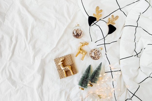 Decorazioni e regali di natale sul letto bianco con una coperta. concetto di vacanza. disposizione piatta, vista dall'alto