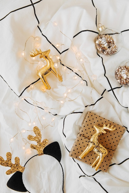 Christmas decorations  and gifts on white bed with a blanket. Holiday concept. Flat lay, top view