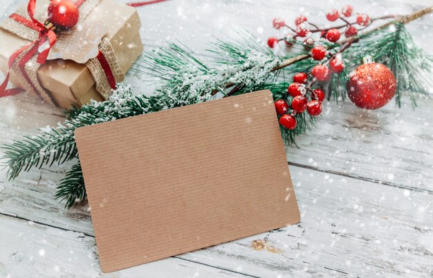 Photo christmas decorations gifts with a craft card with copy space on a wooden background