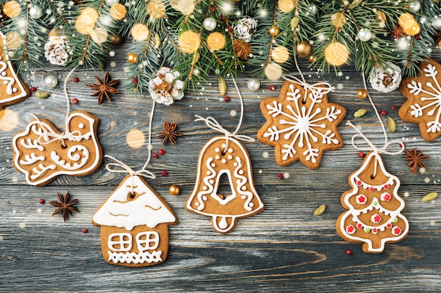 Christmas decorations of Gingerbread cookies & spruce on shining snowy greeting card