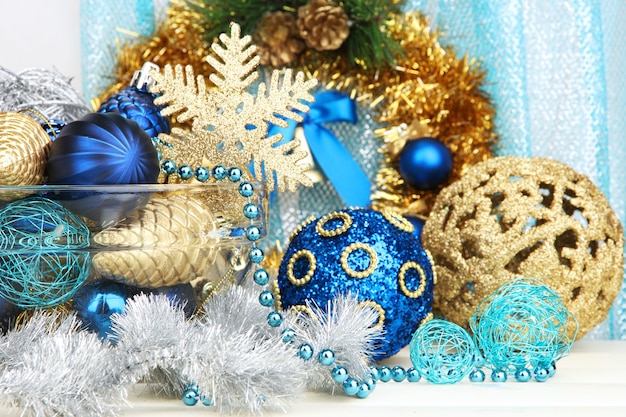 Christmas decorations in glass vase on fabric background