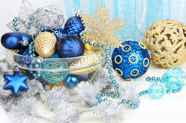 Christmas decorations in glass vase on fabric background