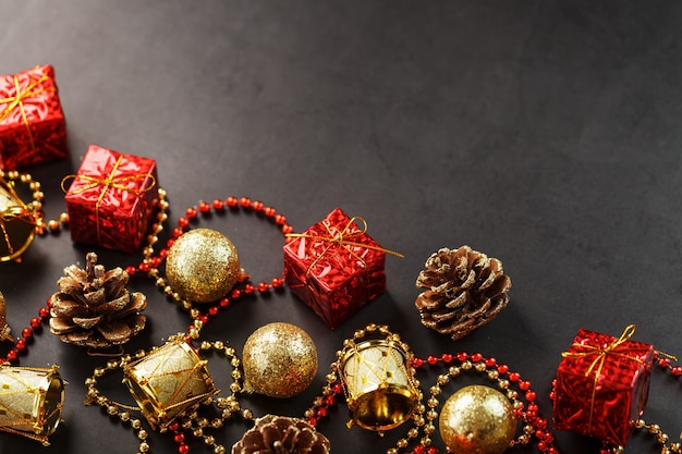 Christmas decorations in gold and red on a black background with free space. View from above. Christmas mood.