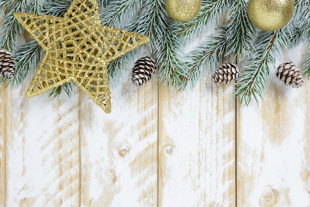 Christmas decorations, golden color balls and stars on a white wooden table. Top view, copy space.