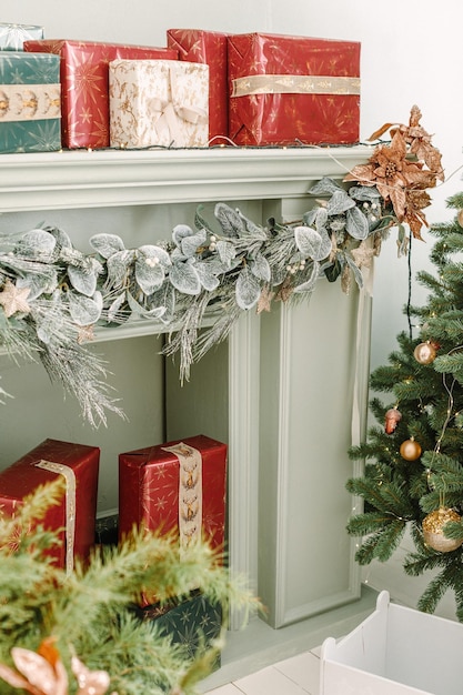 Новогодние украшения дома. Рождественская елка и камин с подарочными коробками. Классический зеленый и красный