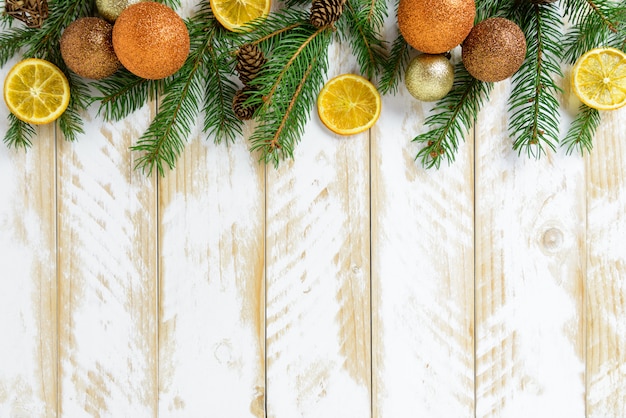 クリスマスの飾り、オレンジ色のボール、白い木製のテーブルにオレンジ色の果物。トップビュー、コピースペース。
