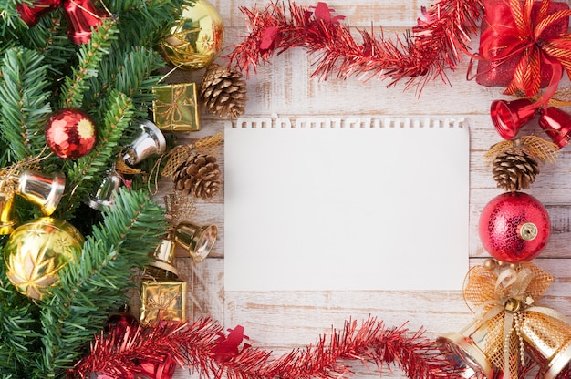 Christmas decorations and paper on vintage white wood background.