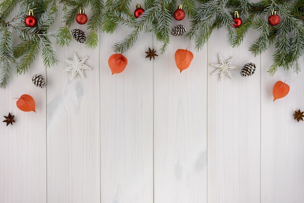 Рождественские украшения, сосновые шишки, звезды и красные шары на белом деревянном столе. Вид сверху, скопируйте пространство.