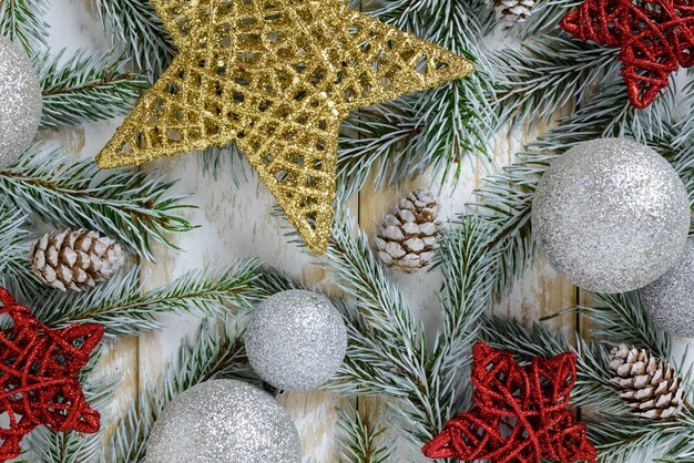 Christmas decorations, pine cones and stars on a white wooden table. Top view, copy space.