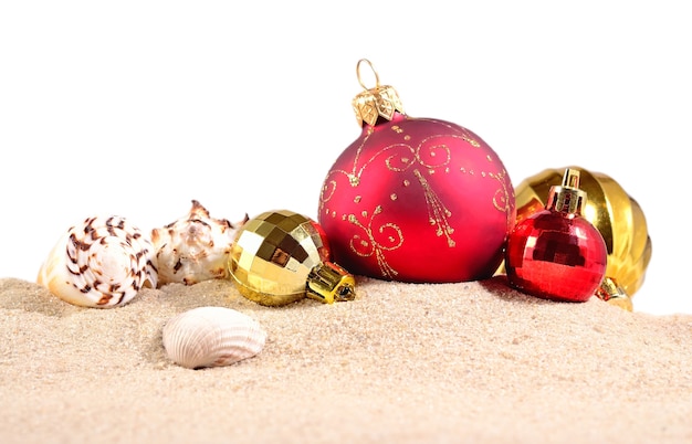 Christmas decorations seashells and starfish on a beach sand on a white background