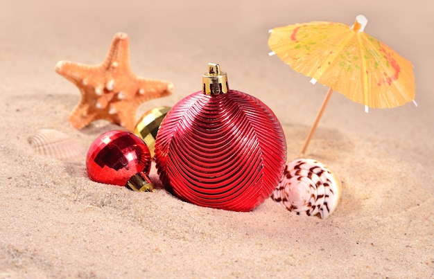 Christmas decorations, seashells and starfish on a beach sand