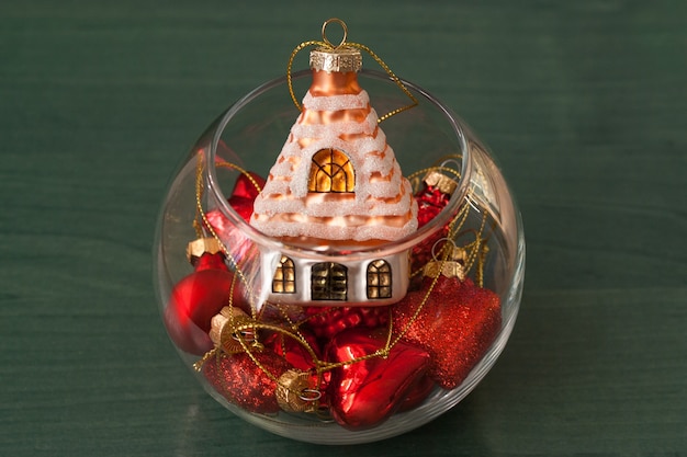 Christmas decorations in a small glass vase on a green background