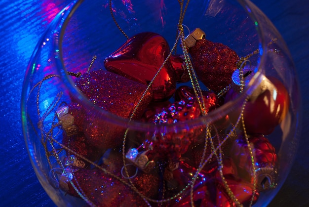 青い背景の上の小さな透明なガラスの花瓶のクリスマスの装飾