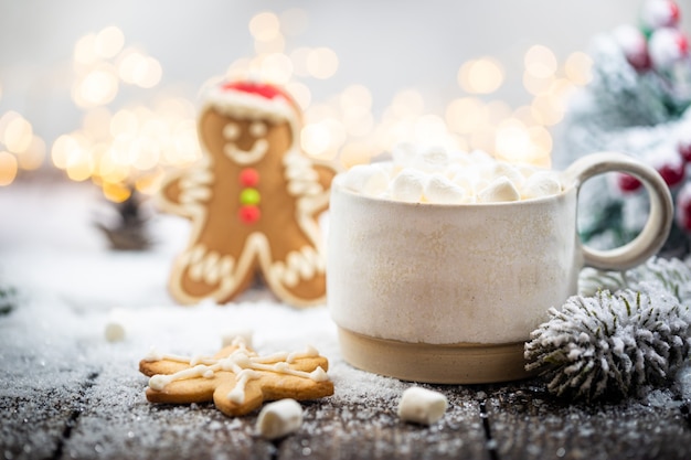 christmas decorations on snow with cup of hot chocolate gingerbread fir tree branches