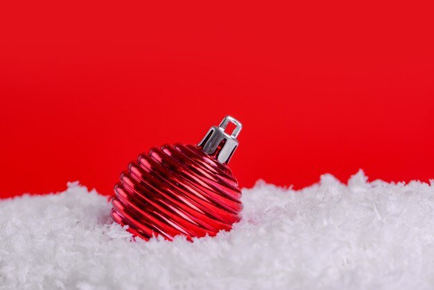 Christmas decorations on snow with red background copy spaceChristmas concept