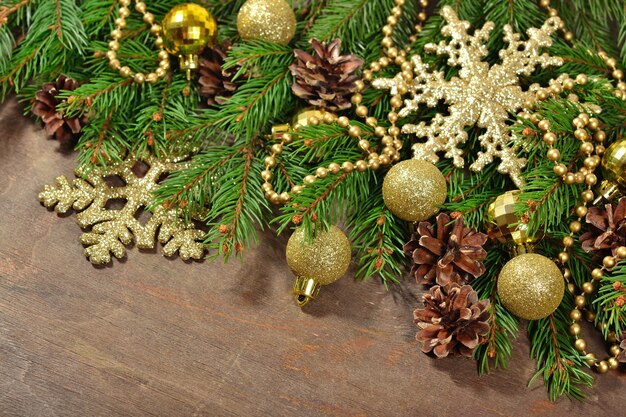 Christmas decorations and spruce branch and cones on a wooden background