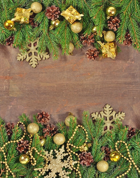 Christmas decorations and spruce branch and cones on a wooden background