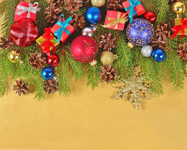 金色の背景のトウヒの枝のクリスマスの装飾