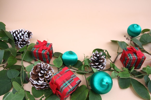 Christmas decorations and vines and dried pine cones on a light yellow background.