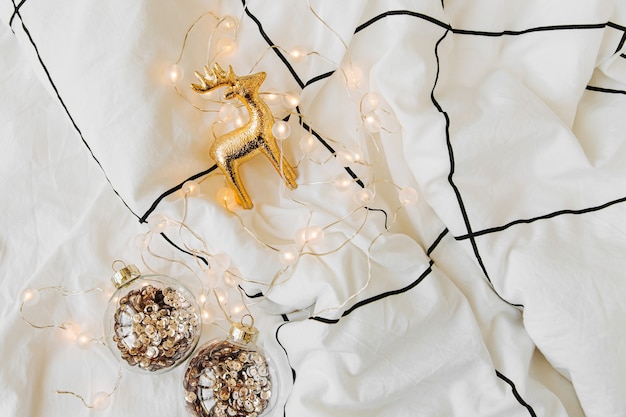 Christmas decorations  on white bed with a blanket. Holiday concept. Flat lay, top view