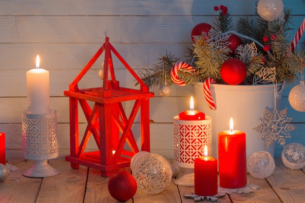 Christmas decorations with burning candles on blue wooden background