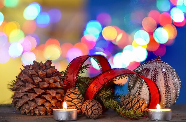 Photo christmas decorations with candles , red ribbon, balls, and colored blurred background.