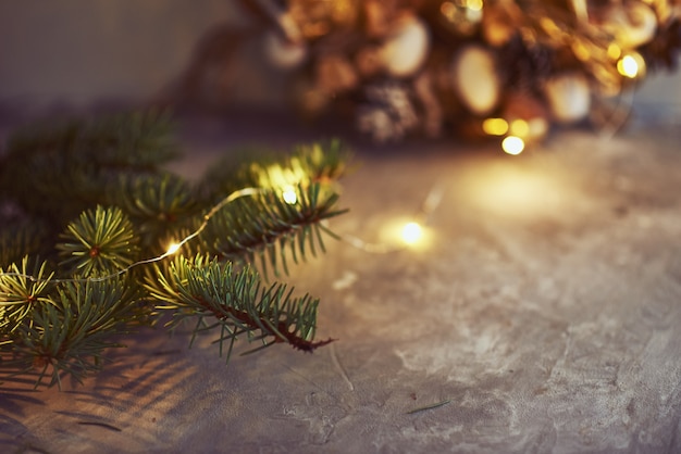 Christmas decorations with garland lights and fir tree branch on a dark background