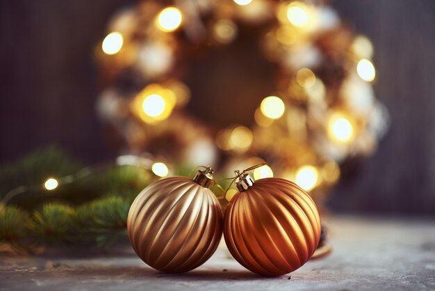 Christmas decorations with golden balls, fir tree branch and garland lights on a dark background