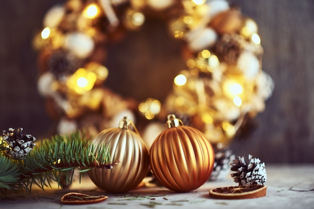 Christmas decorations with golden balls and garland lights on a dark background