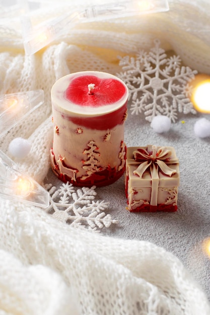 Christmas decorative candles on a white knitted background.