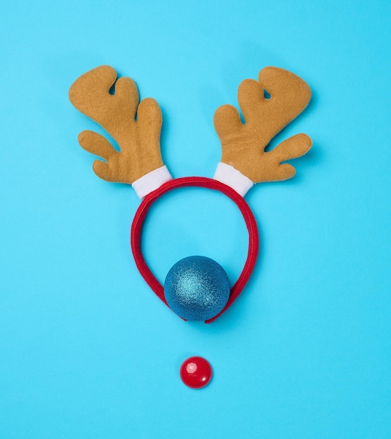 Christmas deer costume with antlers on the head on a blue background top view