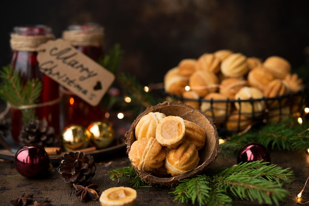 Christmas dessert cookies nuts with boiled condensed milk on a dark wall with garlands and Christmas decorations