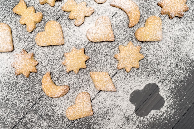 Christmas different shaped cookies with sugar powder on wooden table