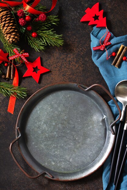 クリスマスディナーのコンセプト、料理の背景。石のカウンタートップに金属板、カトラリー、ナプキン。石のカウンタートップのテーブルセッティング。フラットレイの上面図。