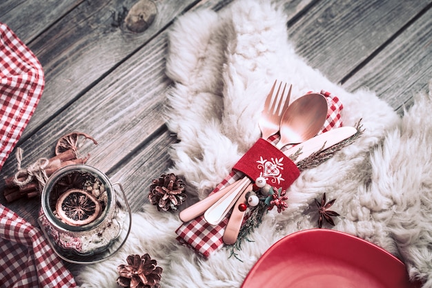 Posate per la cena di natale con decorazioni su una parete di legno