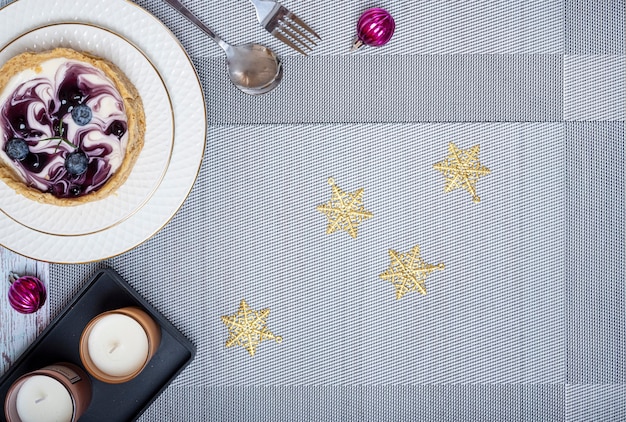 Christmas dinner table decorations with a piece of blueberry cheesecake