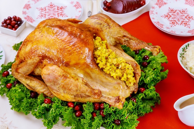 Tavolo da pranzo di natale servito con tacchino, decorato con cavolo riccio e mirtillo rosso. concetto di vacanza di capodanno.