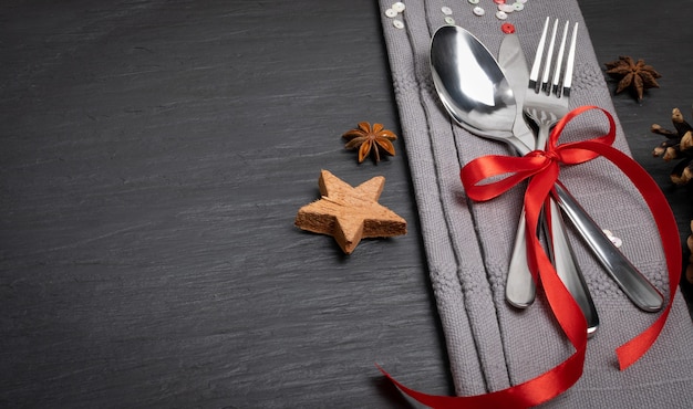 Christmas Dinner Table Setting with Cutlery, Grey Napkin and Winter Spices Top View.