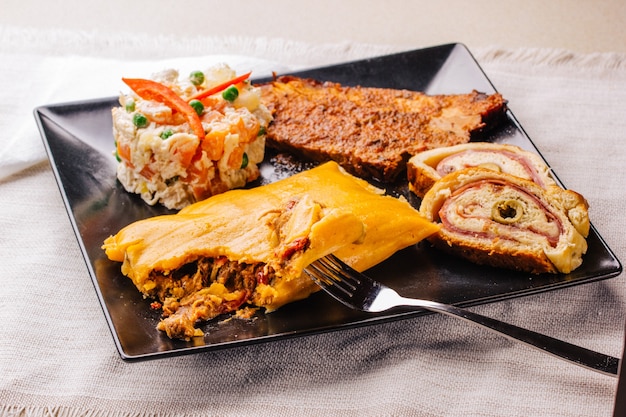 Christmas dish in Venezuela, hallaca, ham bread, salad and pork