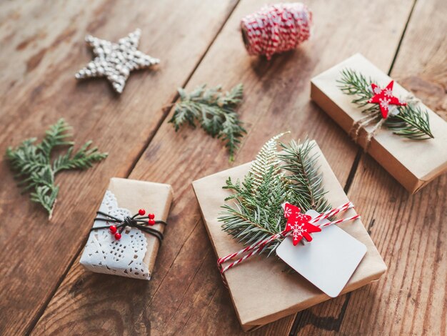 Christmas diy presents wrapped in craft paper with fir tree twigs new year gifts on wooden table