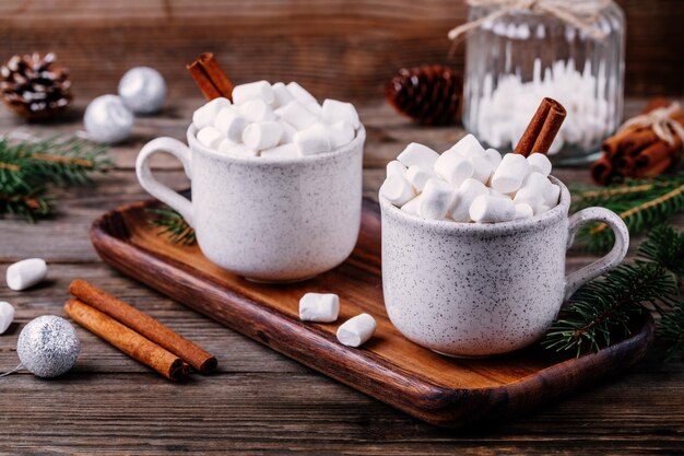 Bevanda di natale cioccolata calda con marshmallow e cannella su fondo di legno scuro