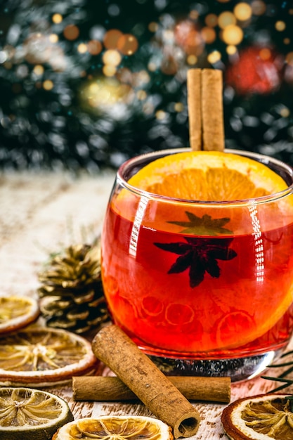 Photo christmas drink sangria or mulled wine, or bray, with apples, oranges, pomegranate and cinnamon sticks.