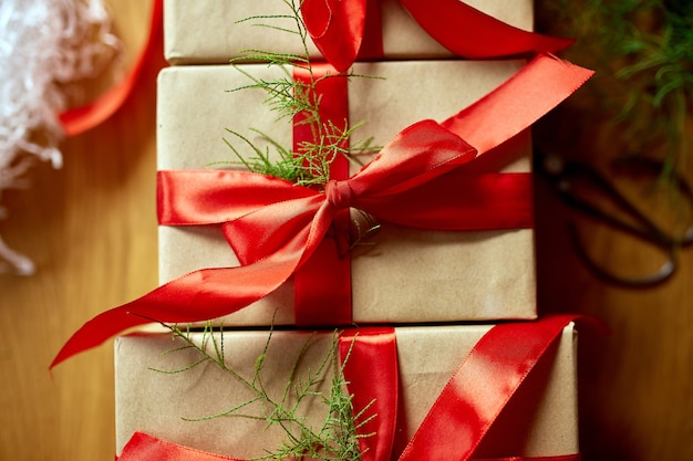 Carta kraft di imballaggio ecologico di natale e rami di abete regali per le festività natalizie, natale su tavola di legno, arredamento ecologico, confezione regalo regalo di natale