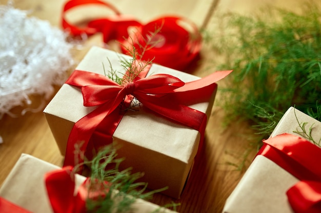 Carta kraft di imballaggio ecologico di natale e rami di abete regali per le festività natalizie, natale su tavola di legno, arredamento ecologico, confezione regalo regalo di natale