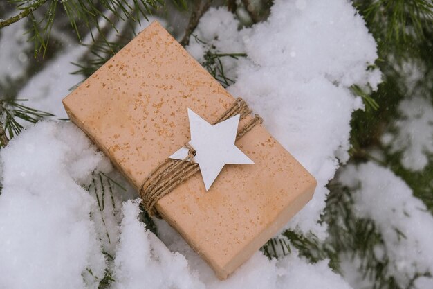 写真 クリスマス エコ ギフト素朴なビンテージ スタイルの冬の休日は雪に覆われたモミの枝の背景ゼロにモックアップします。